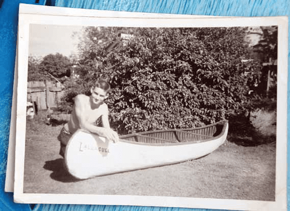 Ross at the age of 16 with a canoe he built.