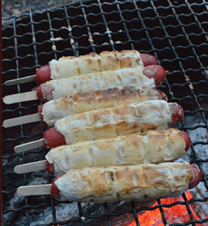 Cooking hot dogs over the fire gives them a nice smoky flavour and they are delicious served with your favourite sauce. Cook over a slow bed of coals to avoid burning.