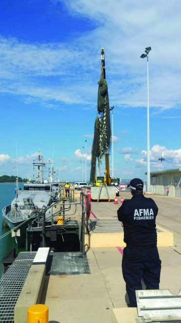 An Australian Fisheries Management Authority officer monitored the unloading of the ghost net in port. Source: Australian Fisheries Management Authority